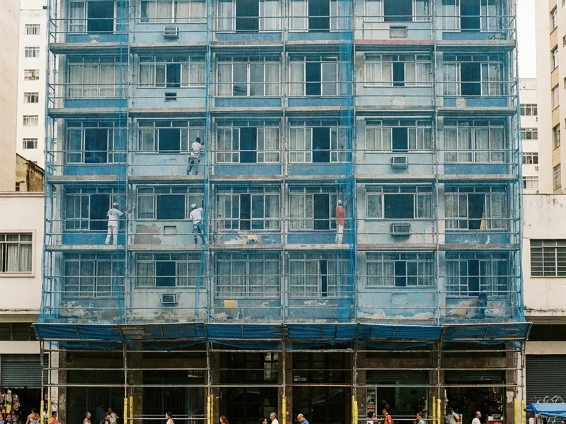 Andaime fachadeiro com tela de proteção cobrindo fachada de edifício