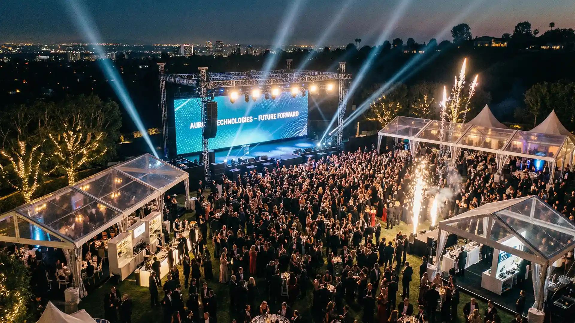Grande evento corporativo ao ar livre com palco iluminado, telas LED e público elegante